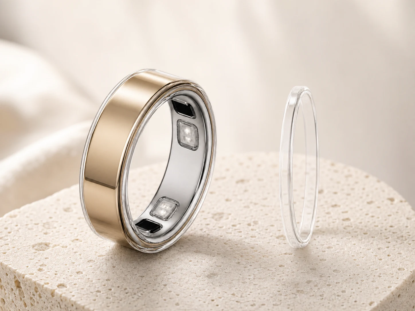 Gold Oura Ring 5 with a fitted clear cover and another cover shown edge-on